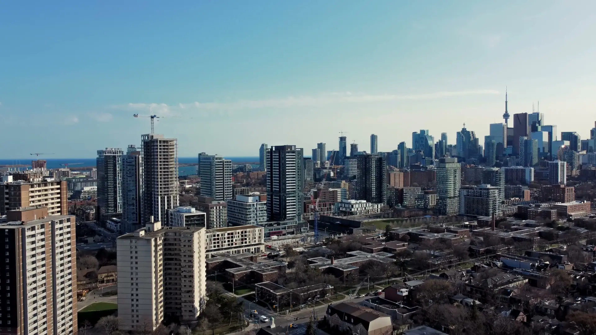 The Toronto skyline from above on a clear day, towers and the CN Tower rising over low streets toward the lake.